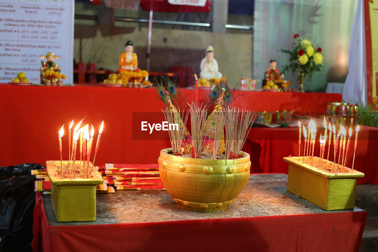 Lit candles on table in illuminated building