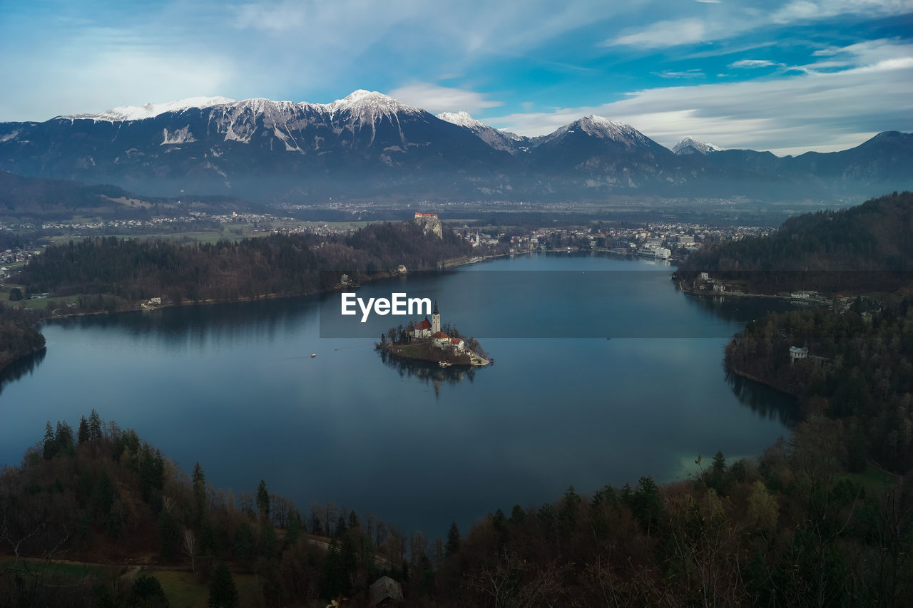 Scenic view of lake by mountains against sky