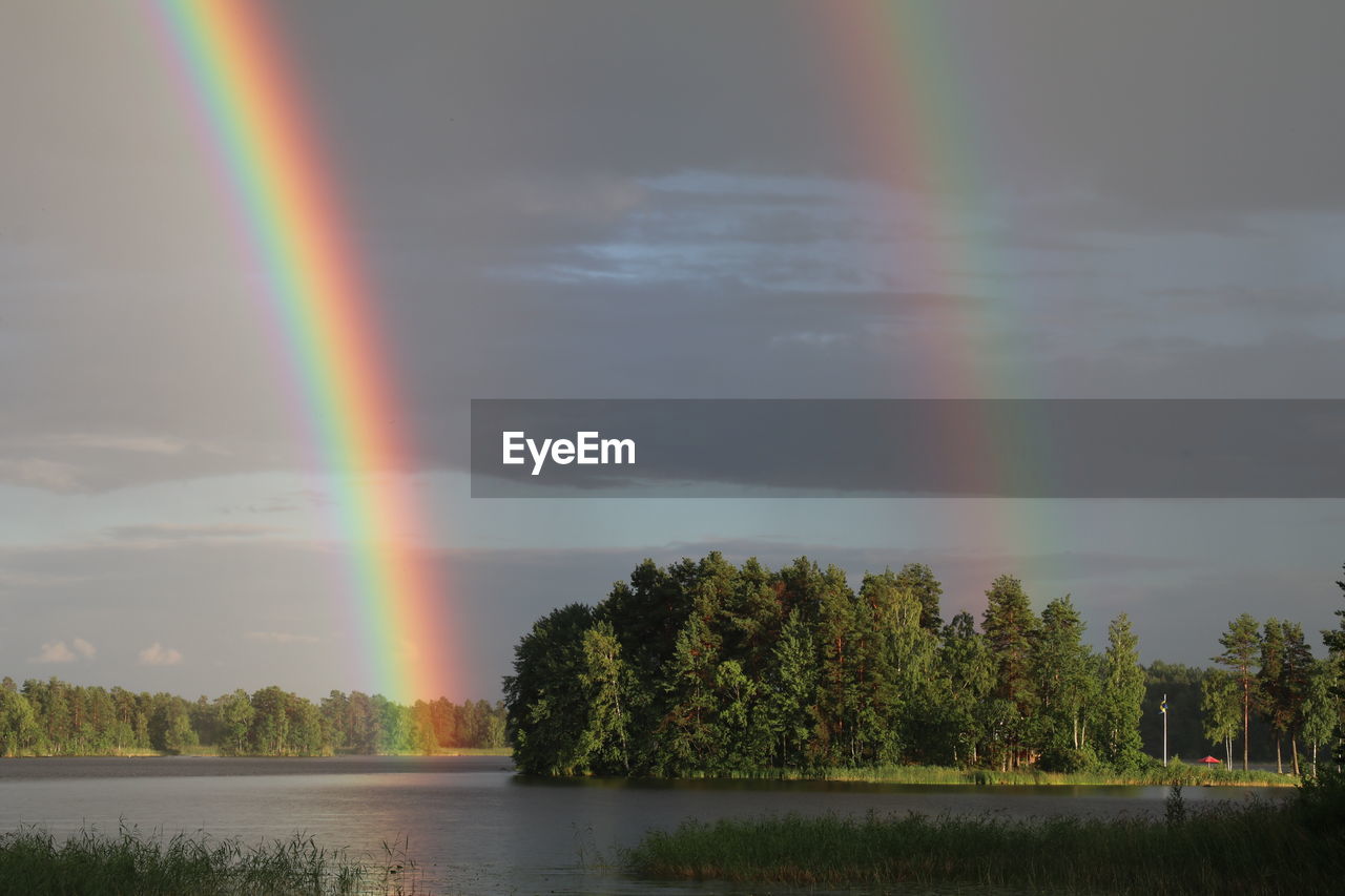 Scenic view of lake against rainbow in sky