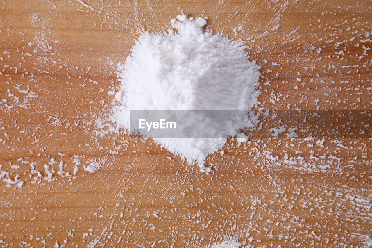Close-up of powdered sugar on wooden table