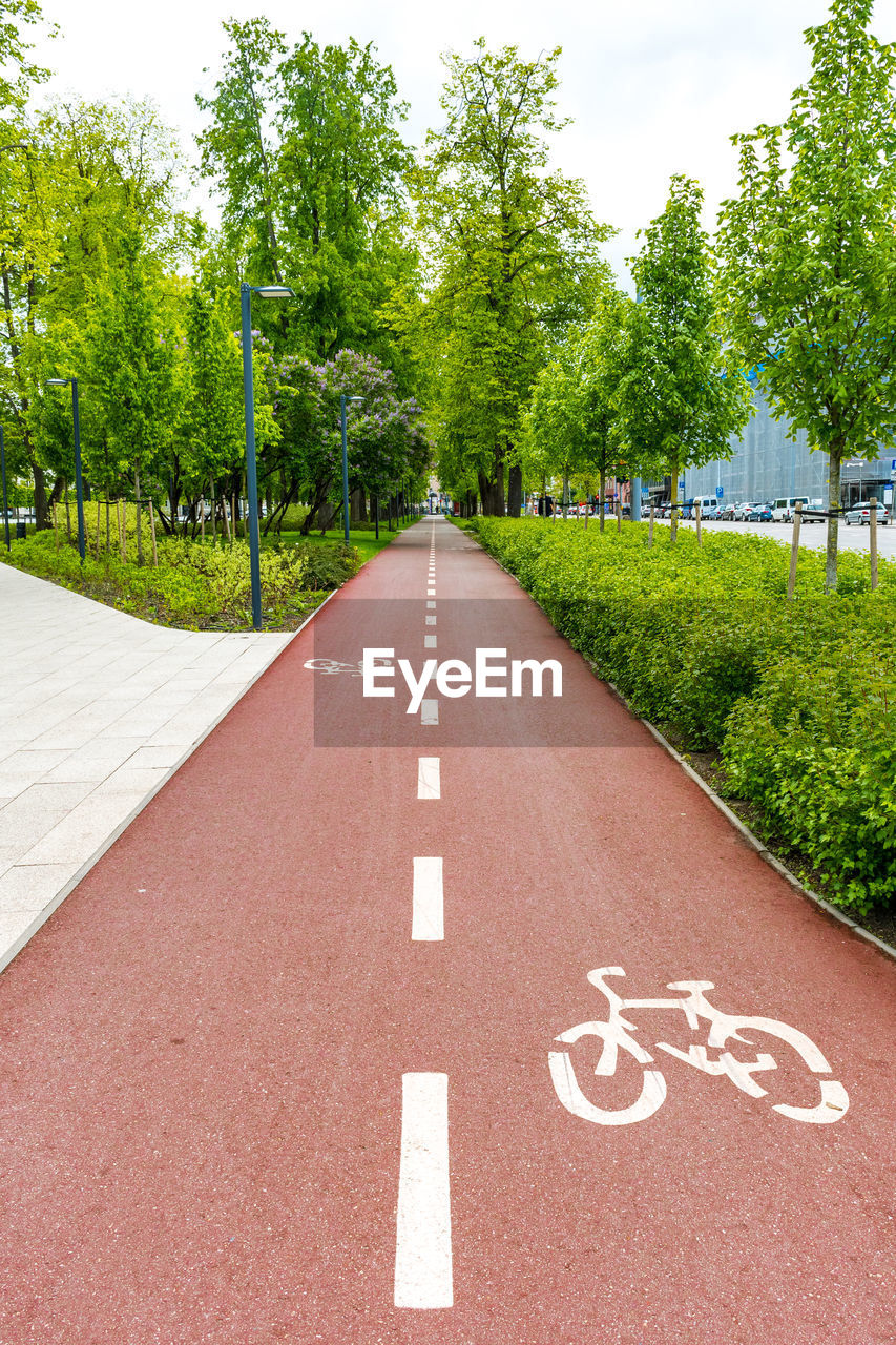 Sustainable transport. blue road sign or signal of bicycle lane, road bike with green trees 