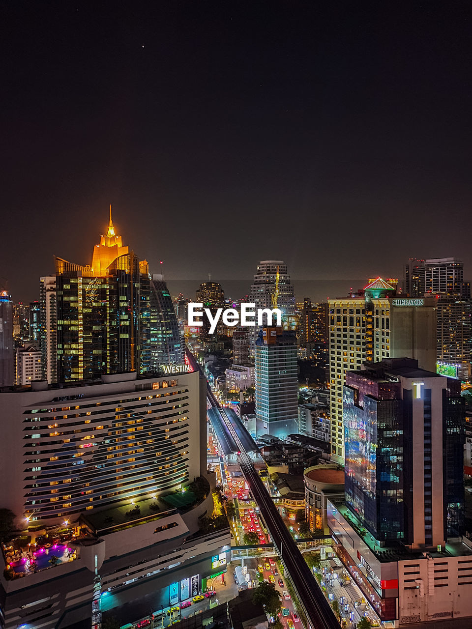 Illuminated buildings in city against sky at night