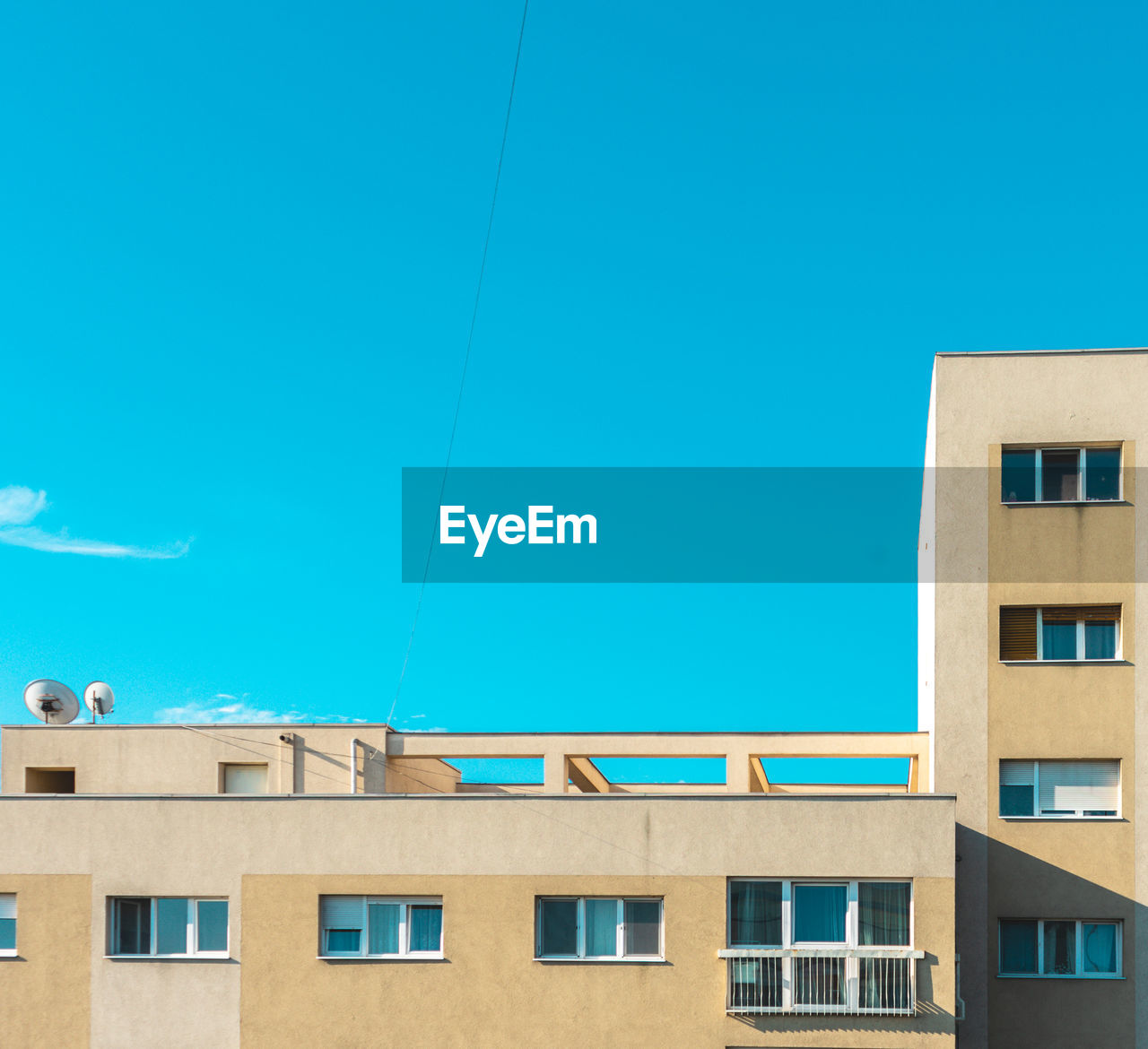 LOW ANGLE VIEW OF RESIDENTIAL BUILDING AGAINST BLUE SKY