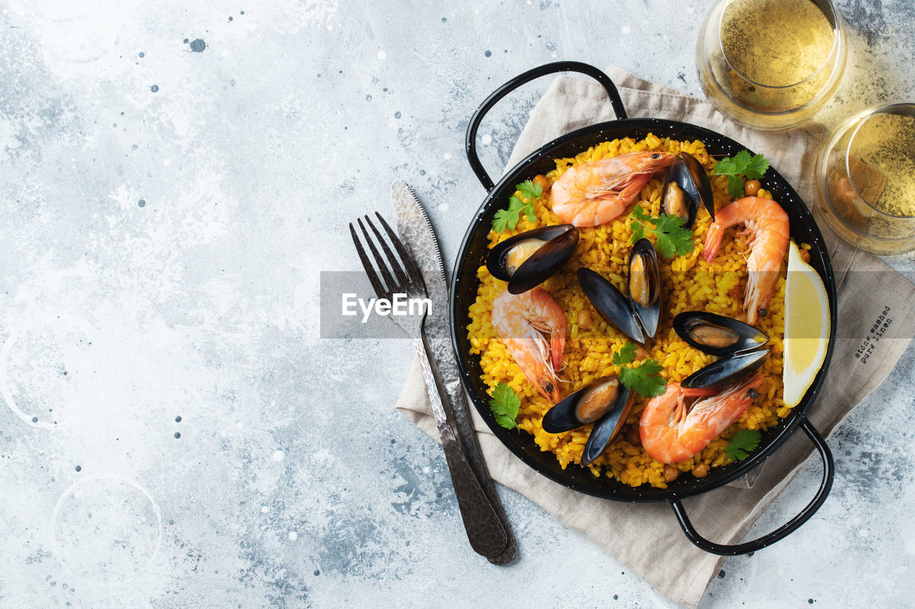Traditional spanish seafood paella in pan with chickpeas, shrimps, mussels, squid.