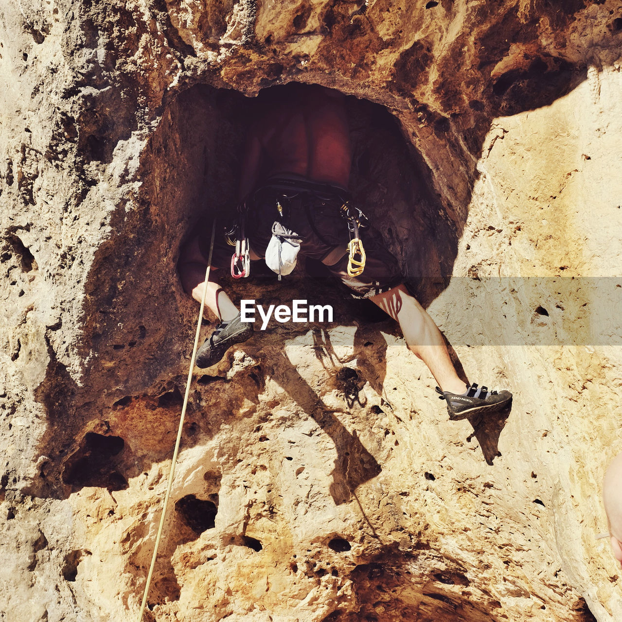 Low angle view of man climbing rock