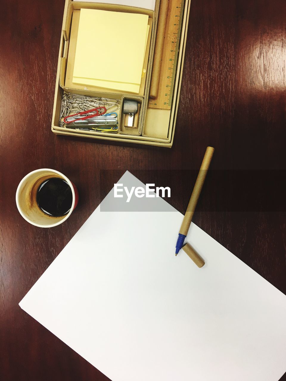 High angle view of blank paper with pen on wooden table