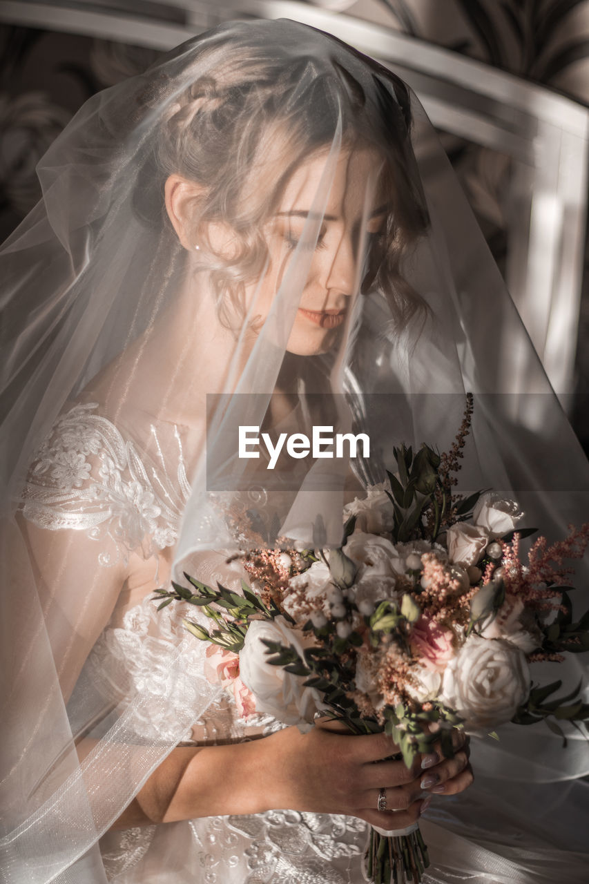 portrait of smiling young woman with bouquet