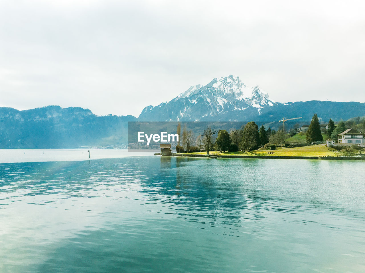 Idyllic view of lake by mountain against sky