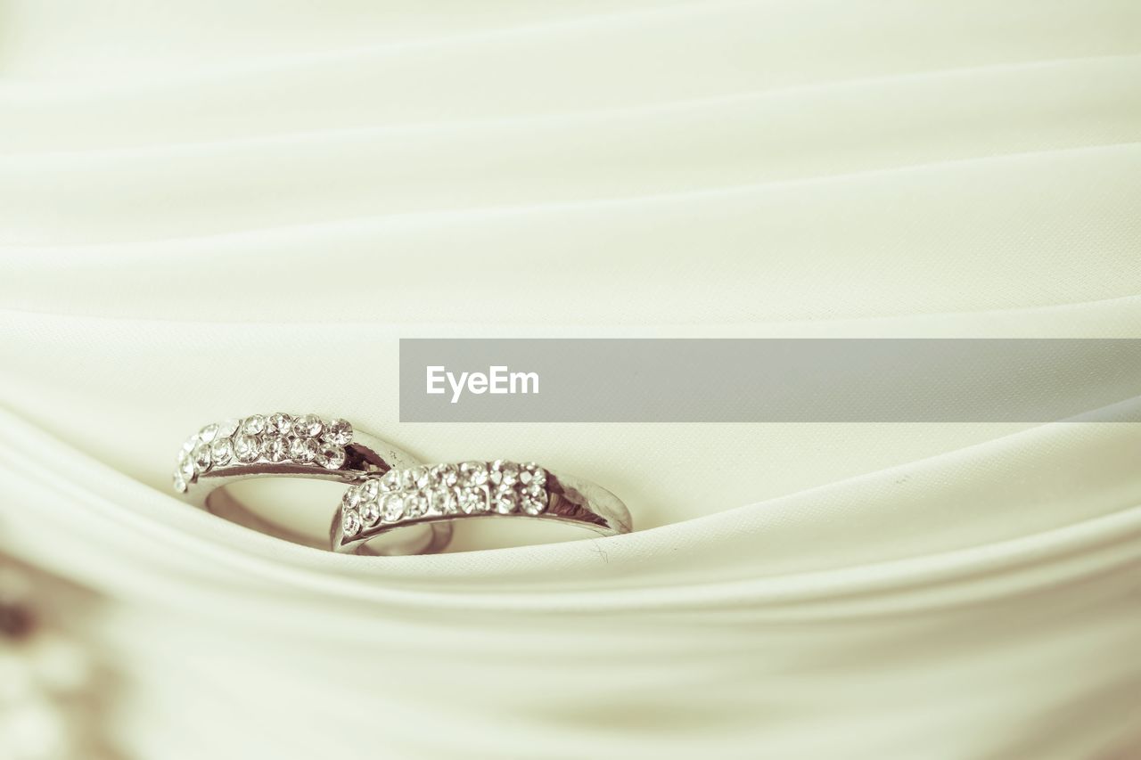 Close-up of wedding rings in white textile