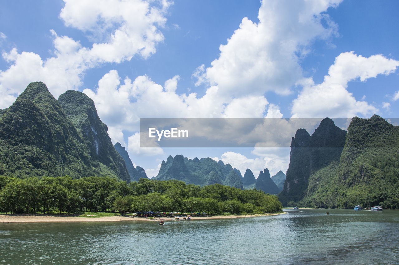 Scenic view of sea and mountains against sky