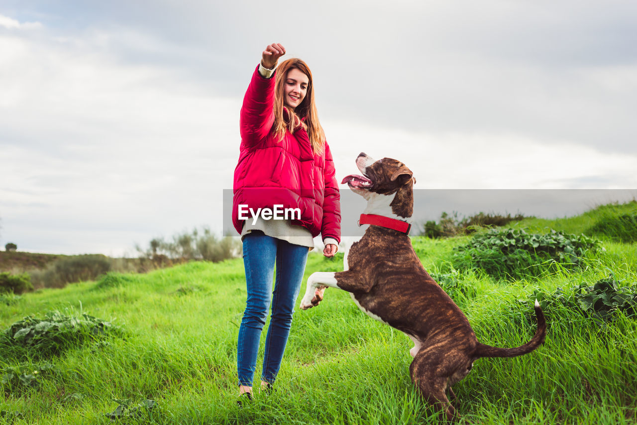 Woman with dog on field