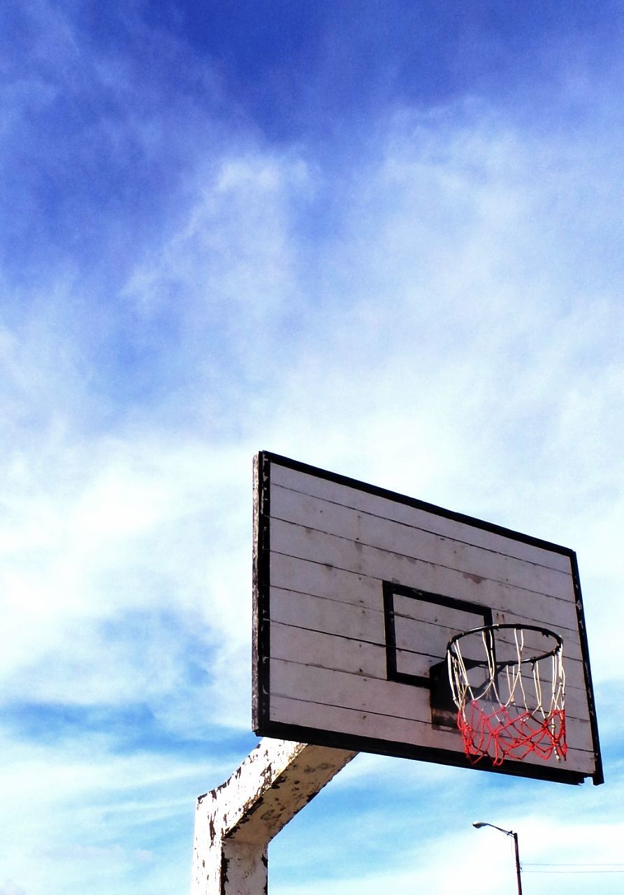 Low angle view of basketball board against cloudy sky