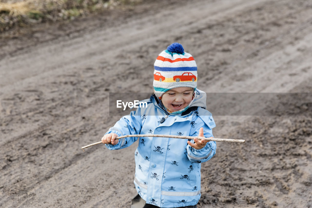 High angle view of cute boy holding stick