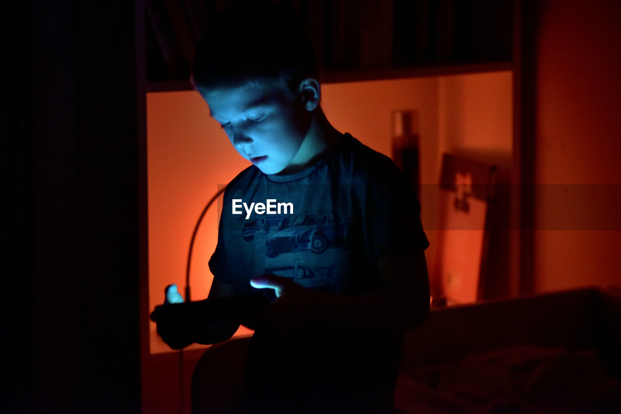 Boy using technology in darkroom