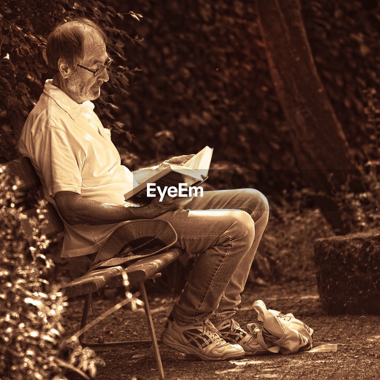 MIDSECTION OF MAN SITTING ON BOOK WITH SEAT