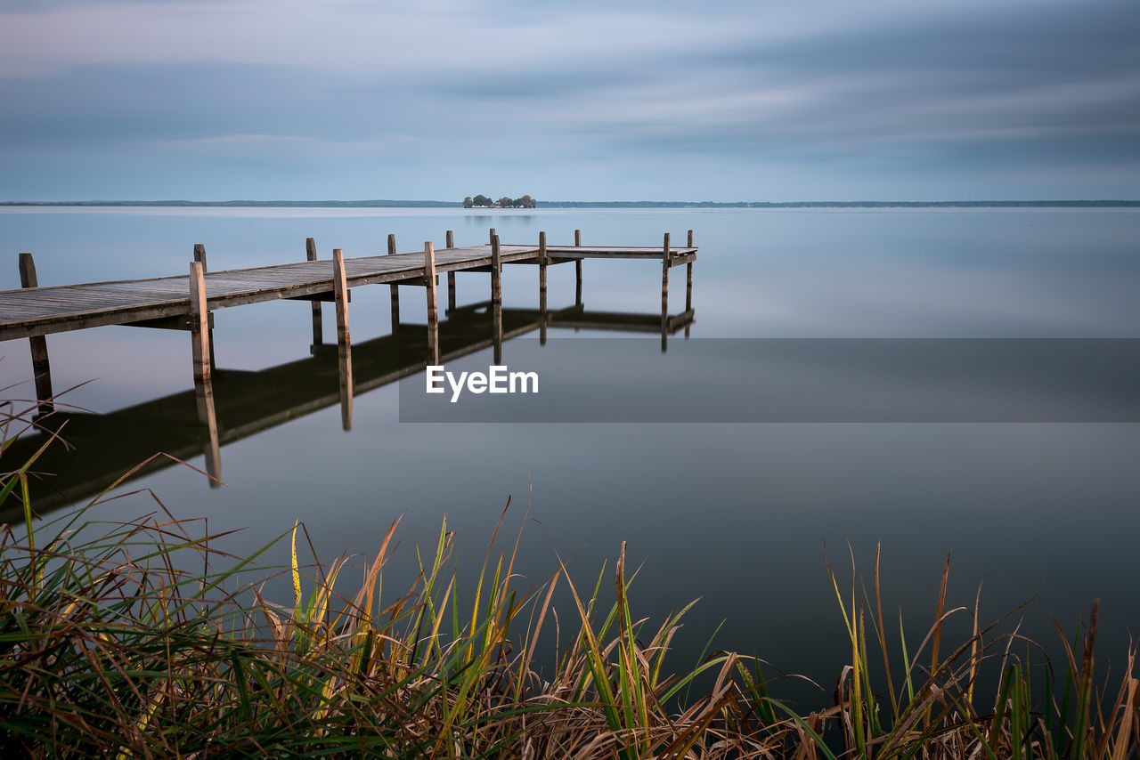 Scenic view of pier on lake against sky