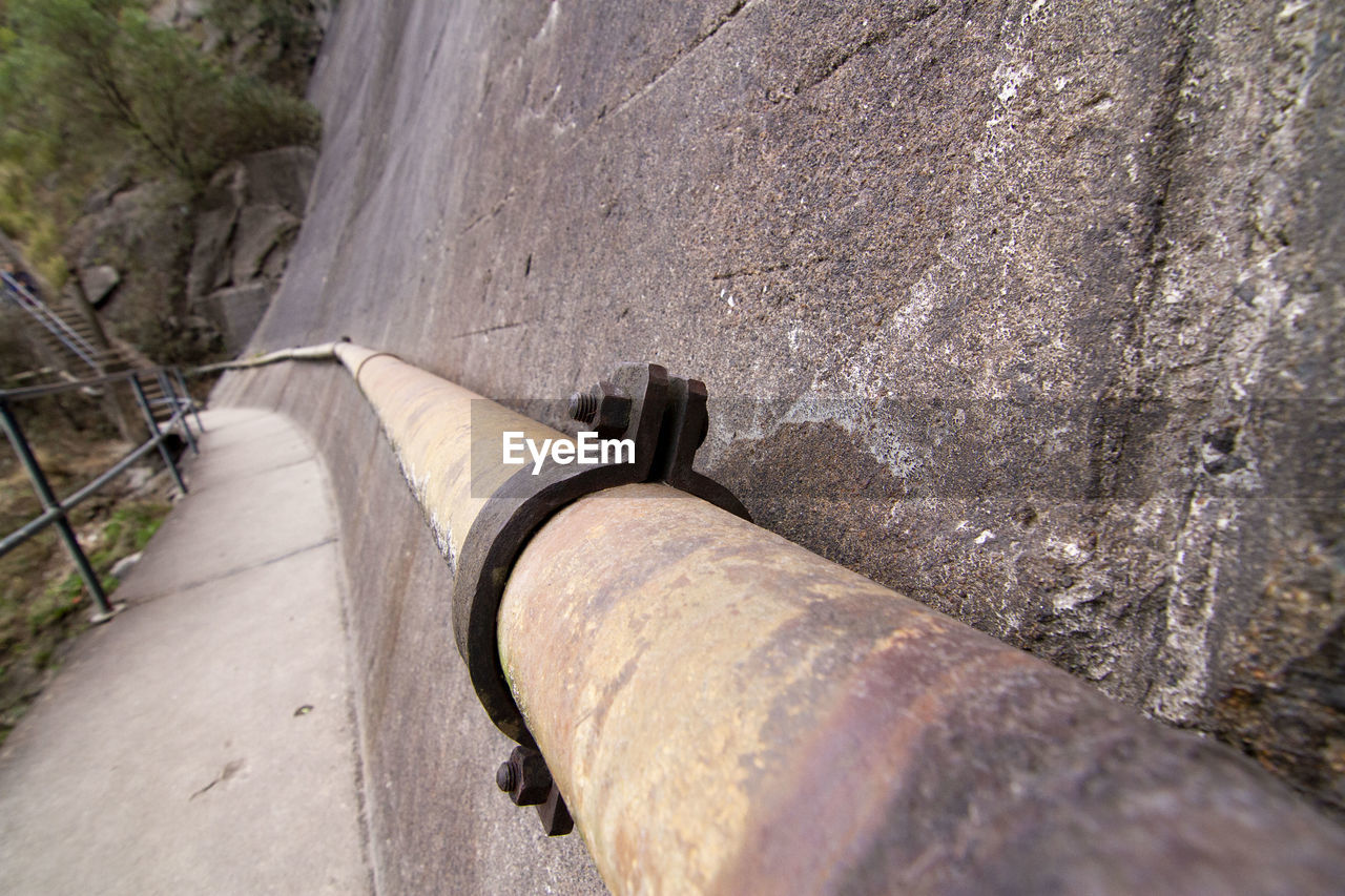 HIGH ANGLE VIEW OF METAL PIPE ON WALL