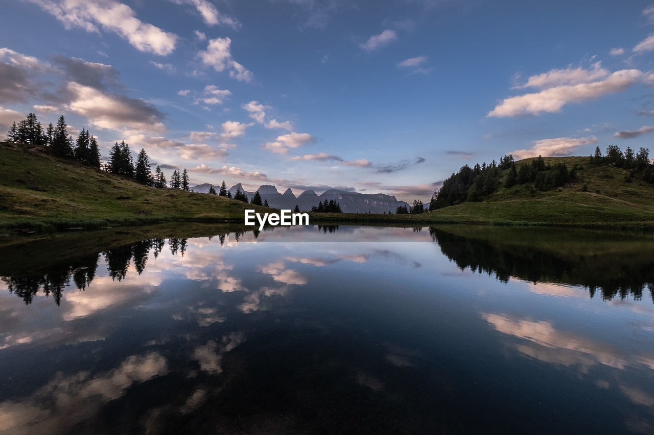 SCENIC VIEW OF LAKE BY MOUNTAIN AGAINST SKY