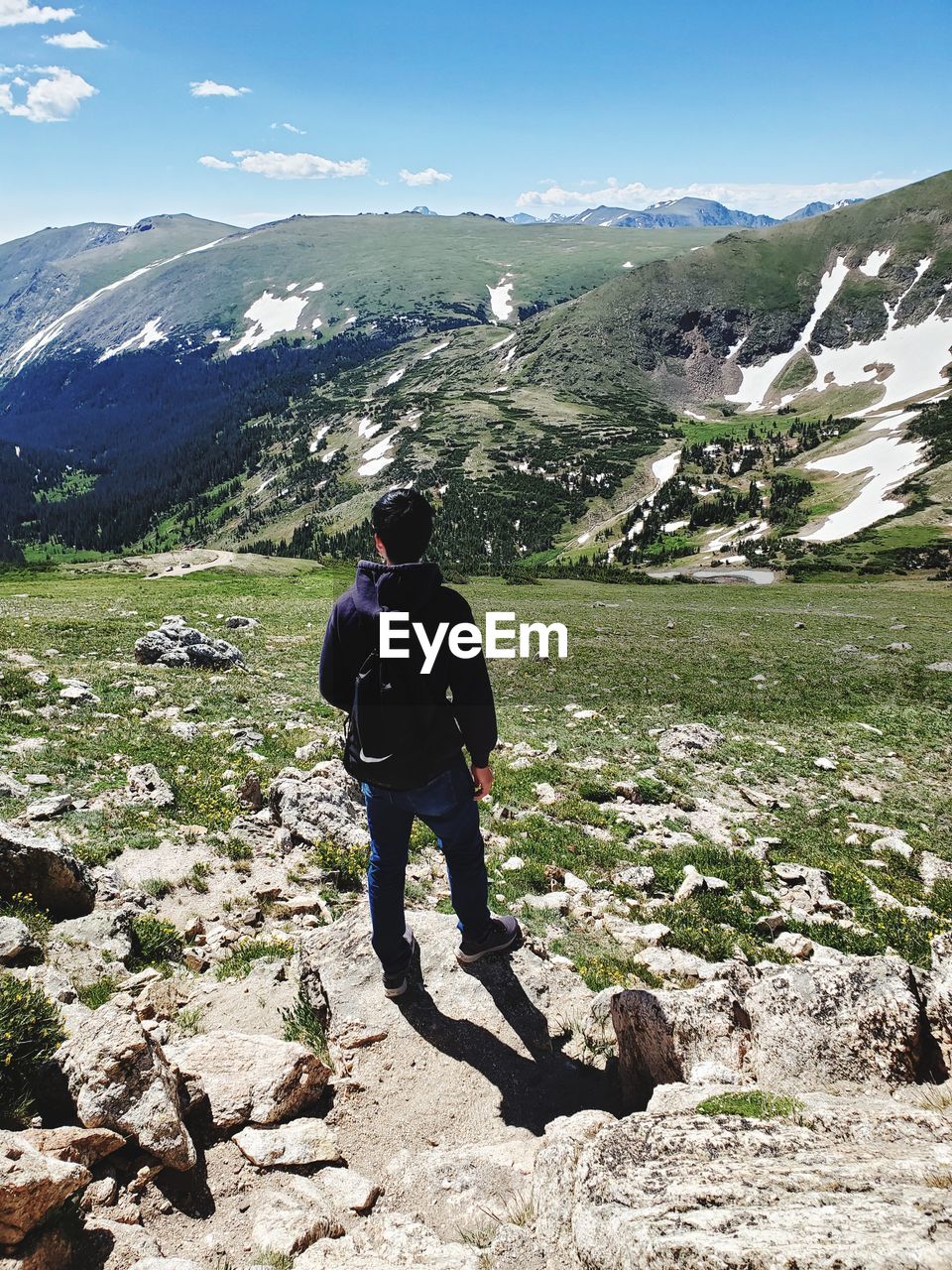 FULL LENGTH REAR VIEW OF MAN ON MOUNTAIN AGAINST SKY