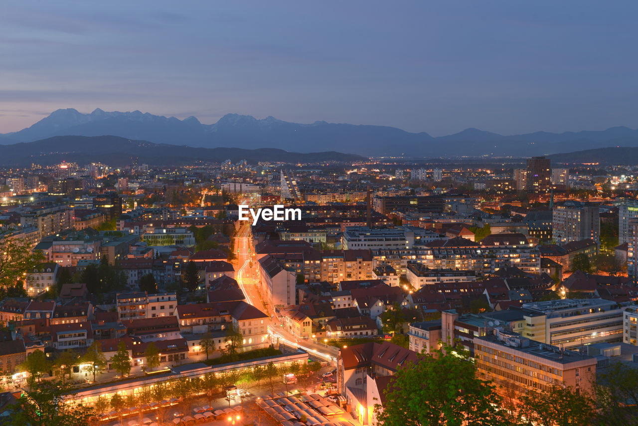 Illuminated cityscape against sky at dusk