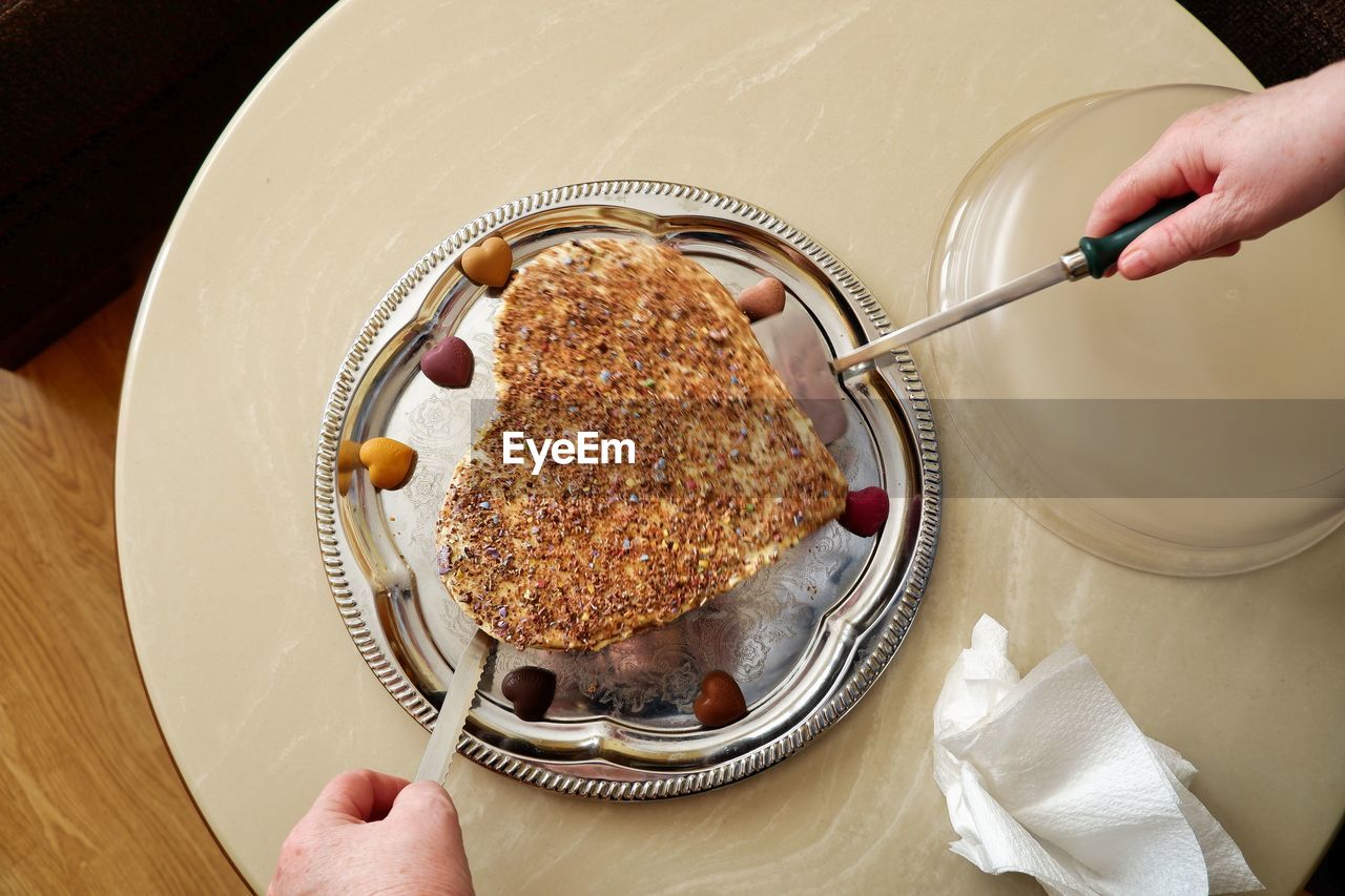 Midsection of person holding cake in plate