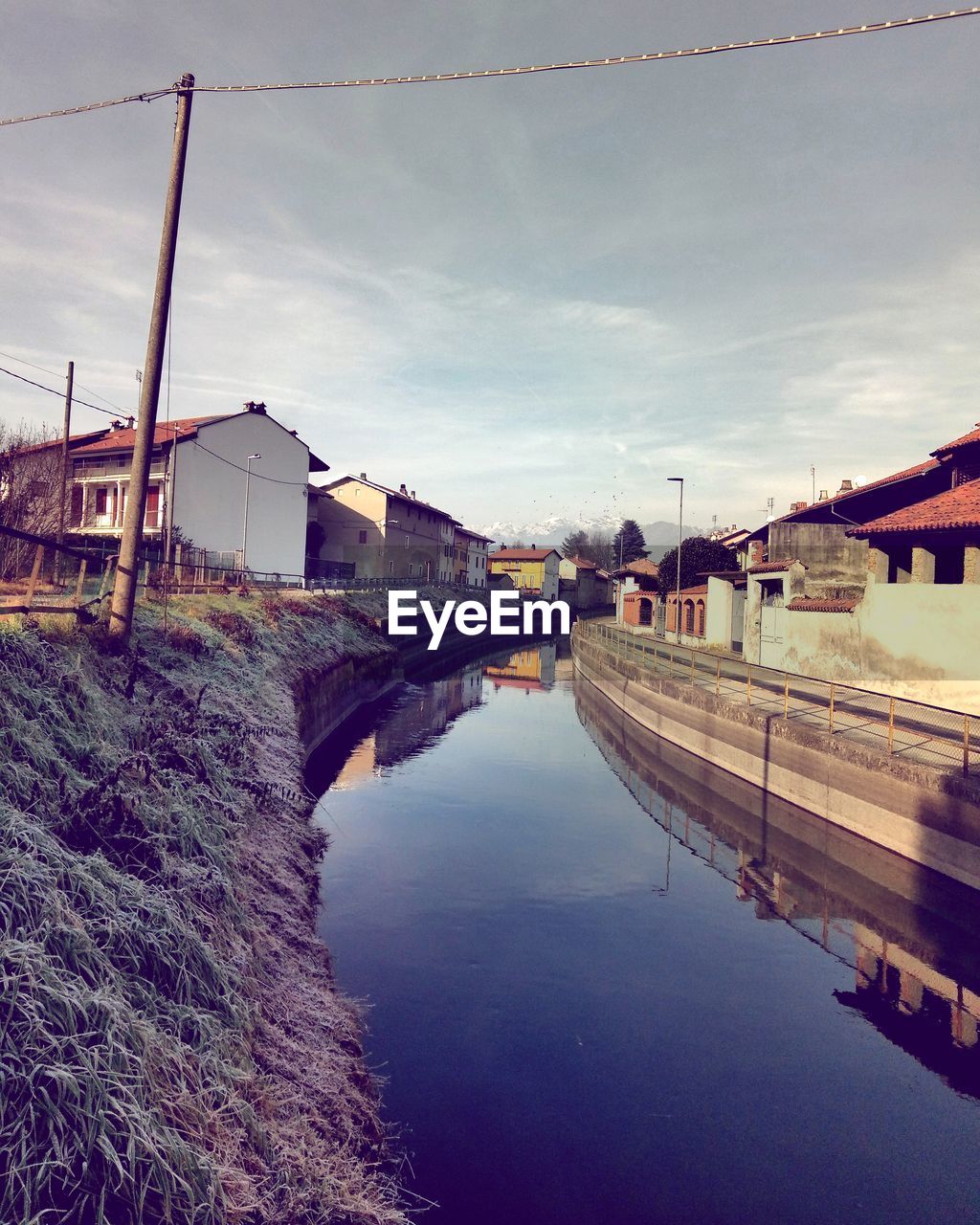 RIVER BY BUILDINGS AGAINST SKY