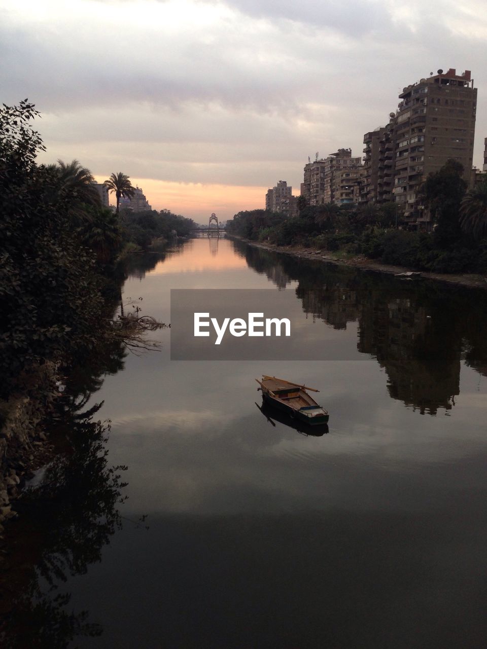 REFLECTION OF SKY ON RIVER IN CITY