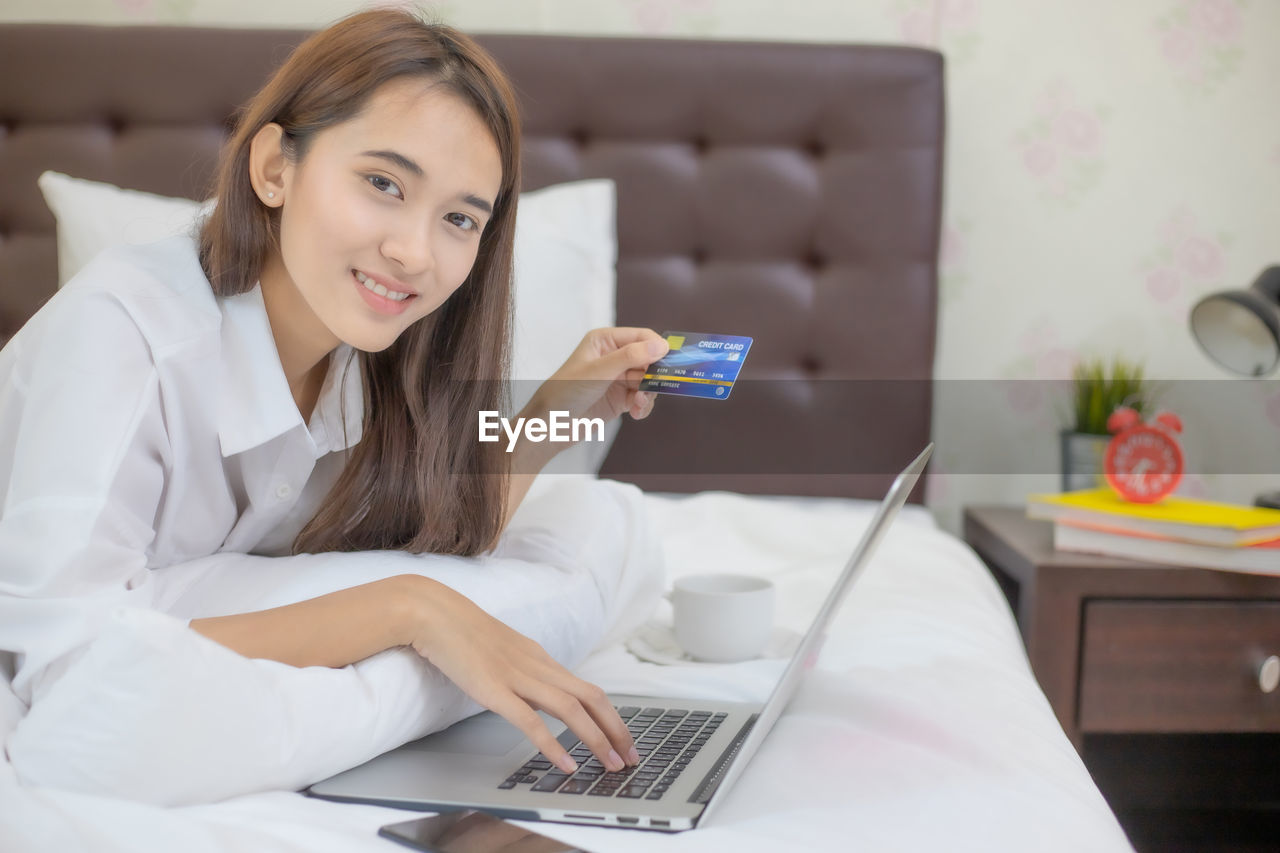 YOUNG WOMAN USING LAPTOP AT HOME