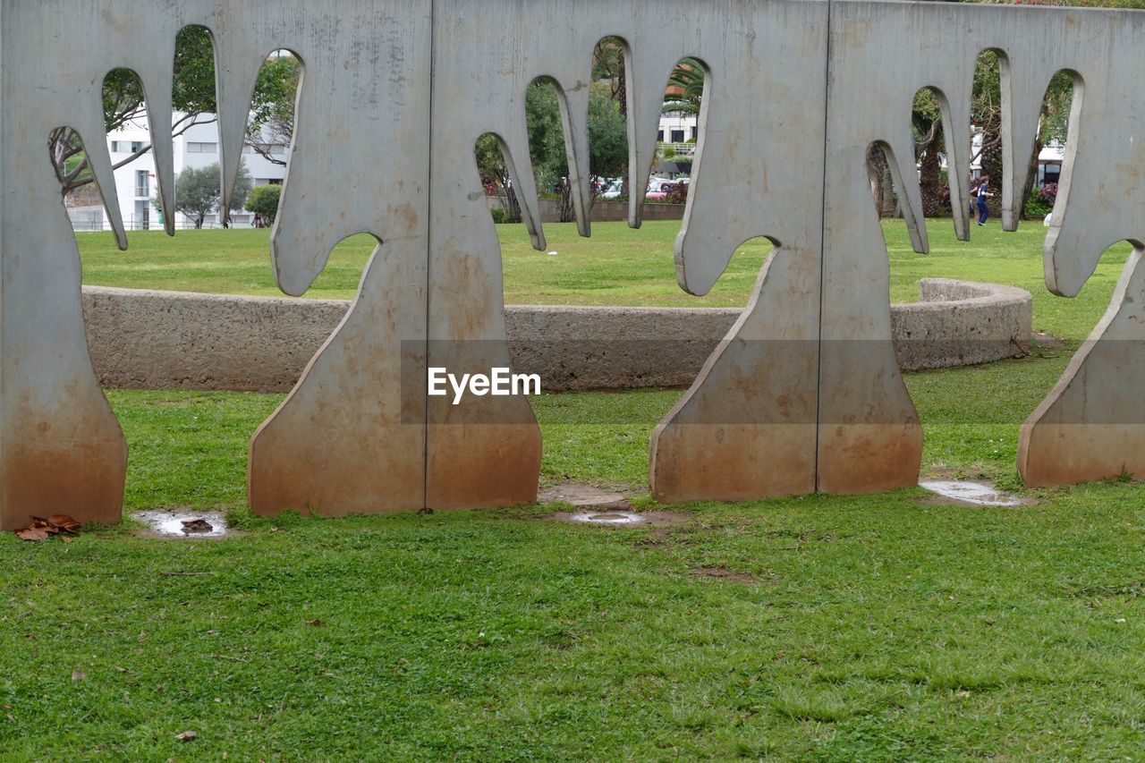 Concrete hand sculptures on field in park