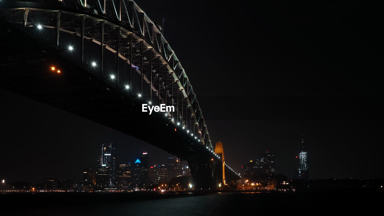 Illuminated city by river at night