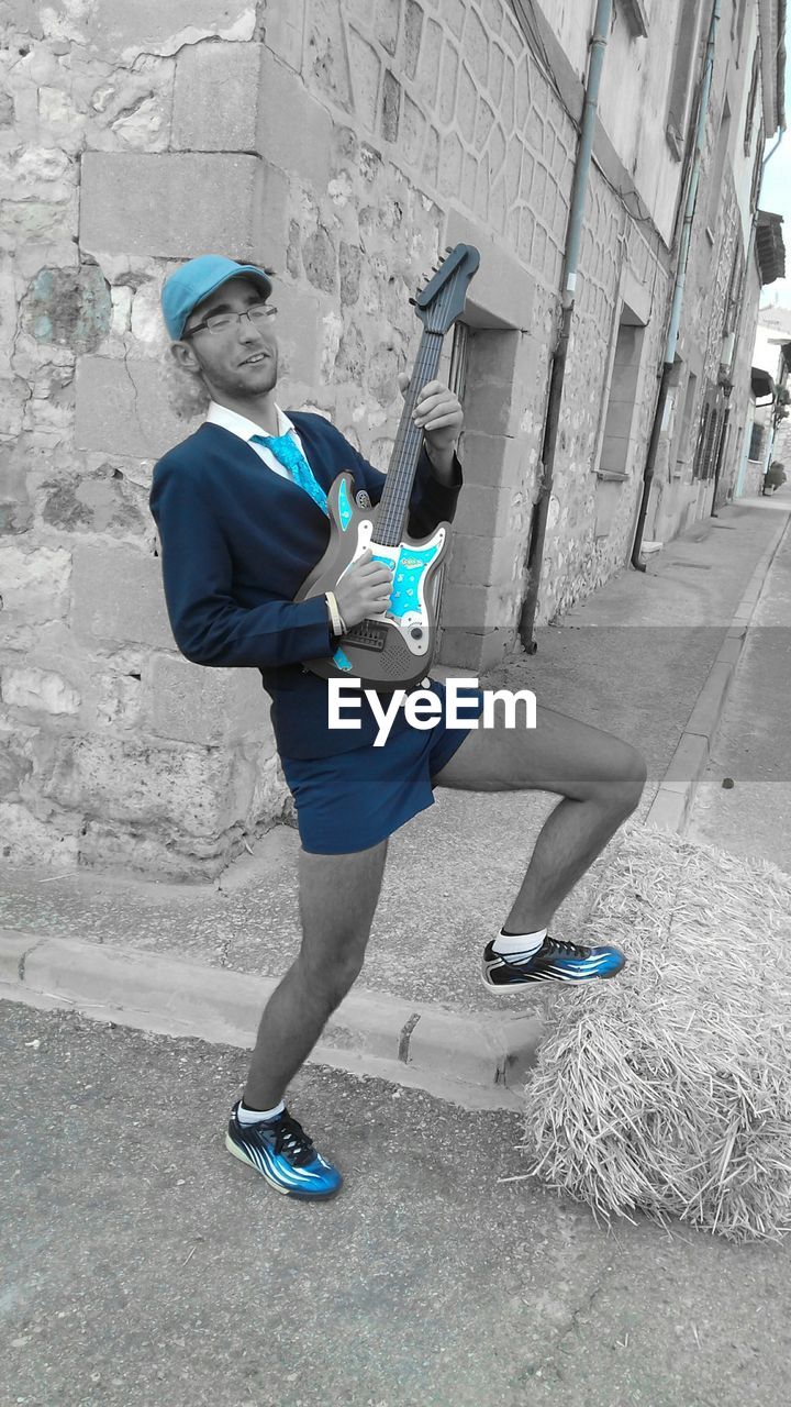 MAN STANDING ON ROAD IN CITY