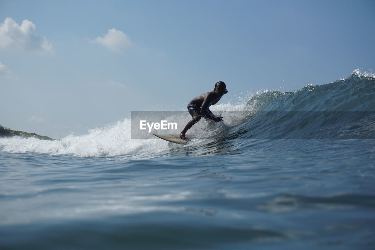 Full length of man splashing water in sea