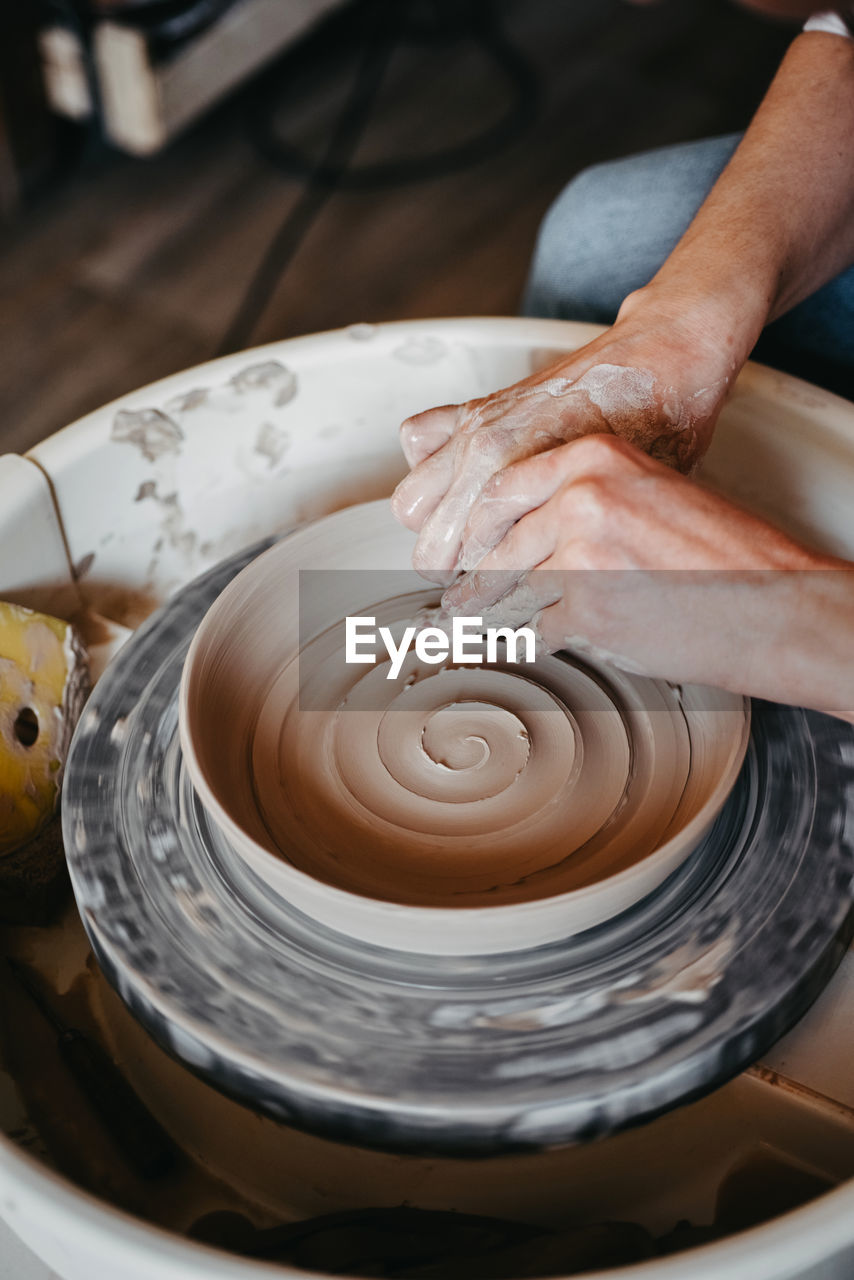 Decorating wet clay on potters wheel with a wine groove