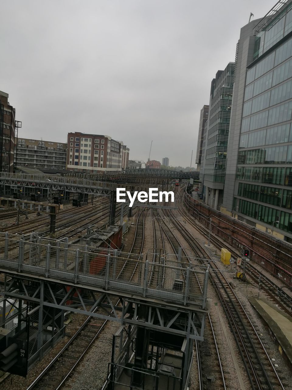 Railroad tracks in city against sky