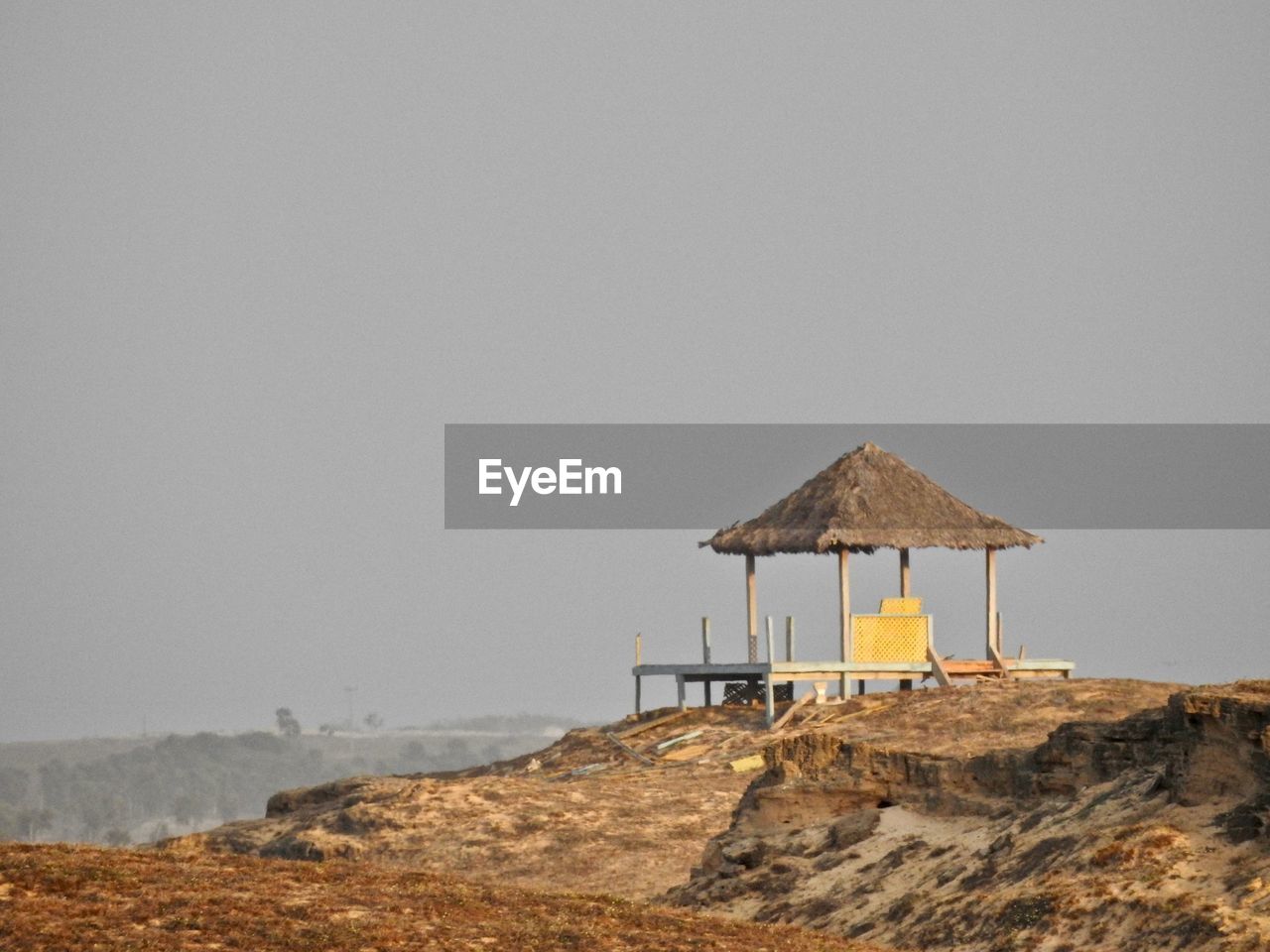 Hut on beach against clear sky