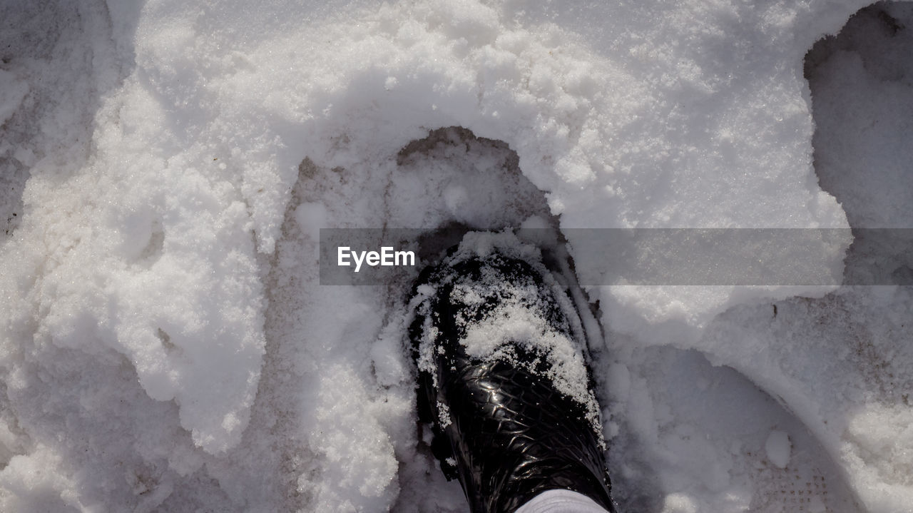 winter, freezing, snow, low section, human leg, ice, one person, personal perspective, shoe, blizzard, cold temperature, nature, footwear, high angle view, white, lifestyles, leisure activity, winter storm, day, frozen, water, outdoors, limb, human limb, human foot, sports, directly above, environment