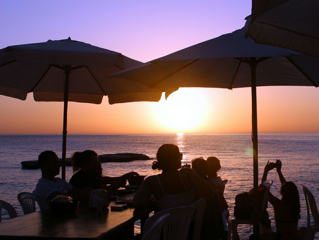 People at outdoor restaurant enjoying sunset