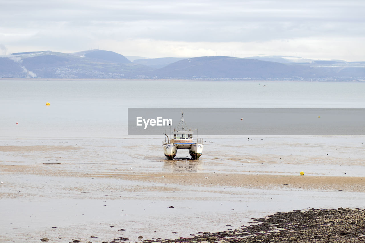 BOAT ON BEACH AGAINST SKY