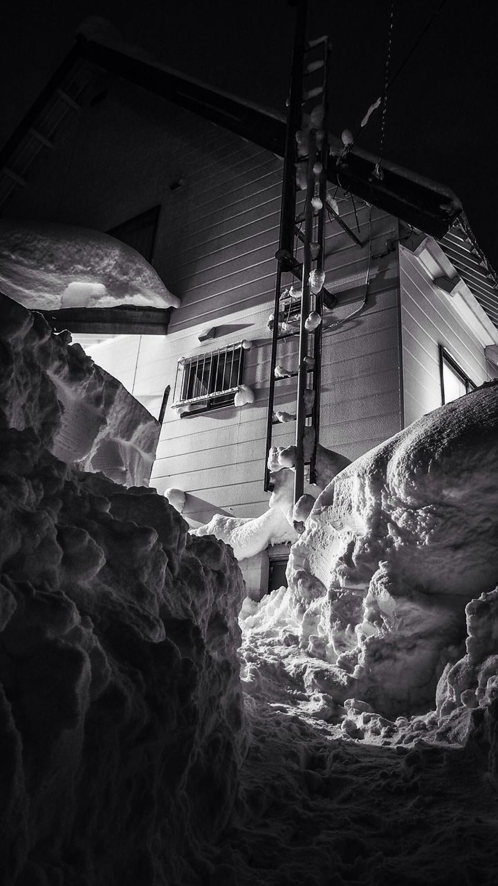 Low angle view of house with deep snow