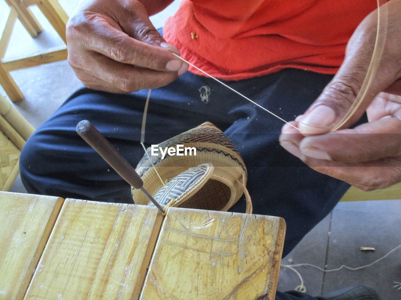 Midsection of man making needlecraft product