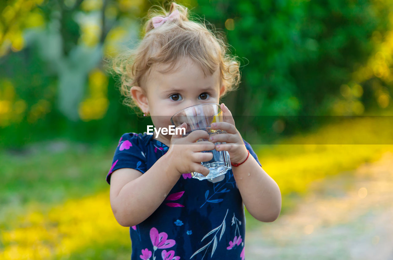 Portrait of cute girl drinking water