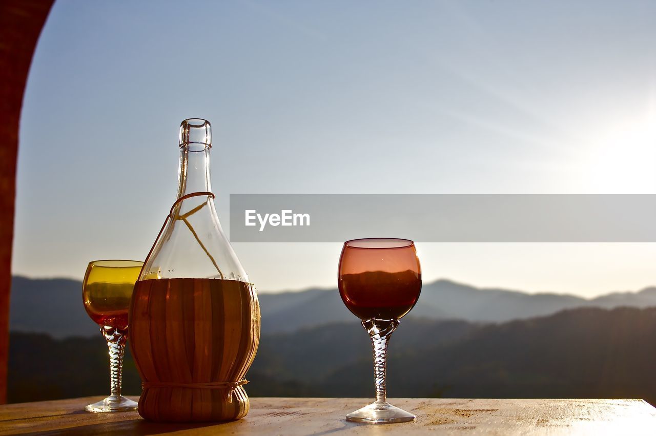 GLASS OF WINE ON TABLE AGAINST SKY