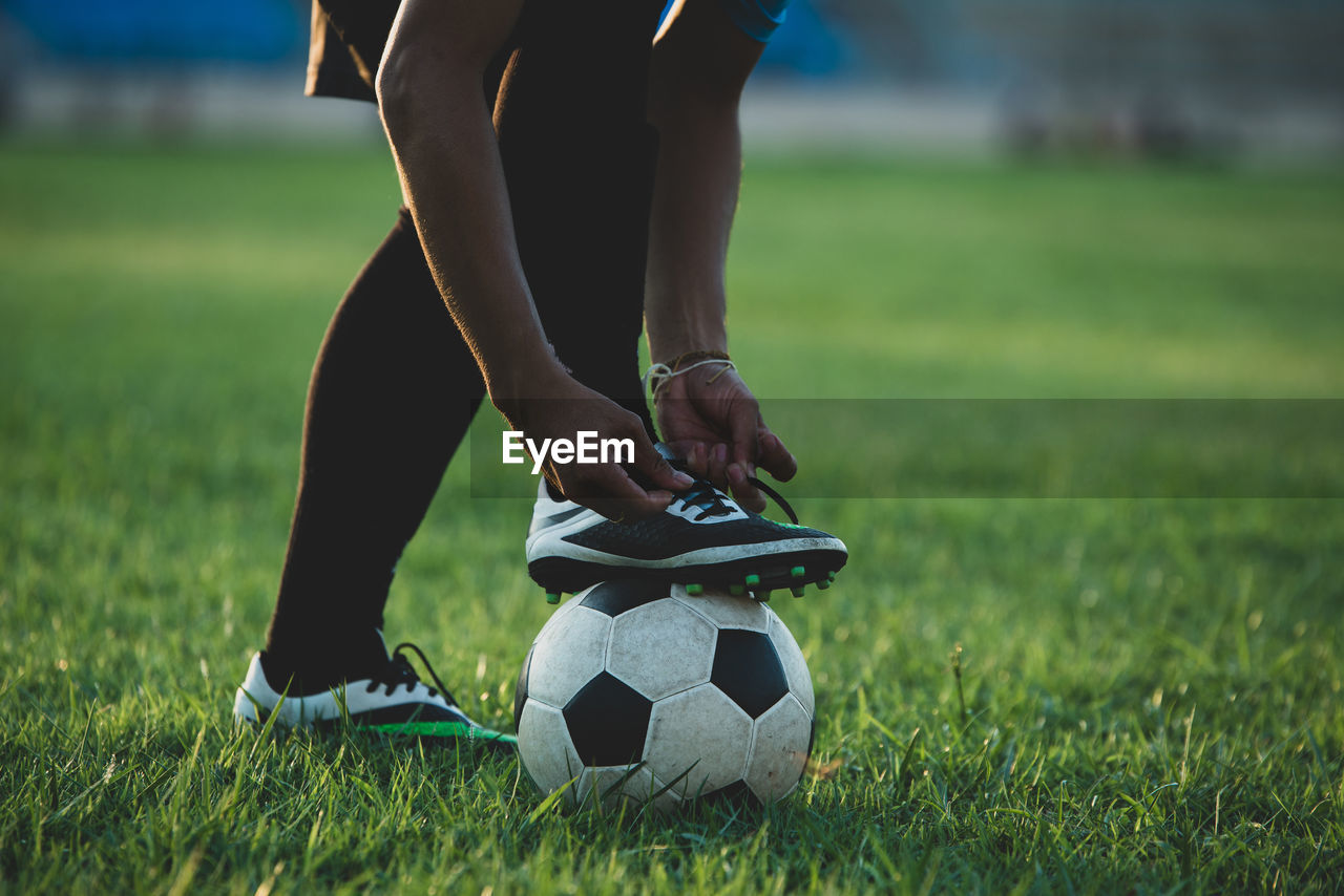 LOW SECTION OF PERSON ON SOCCER FIELD AT PARK