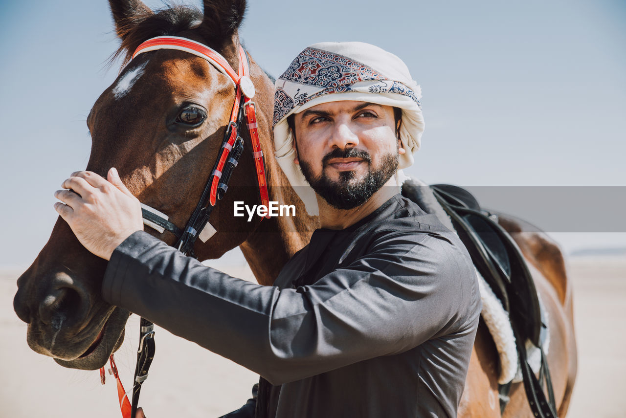 Man standing with horse in dessert