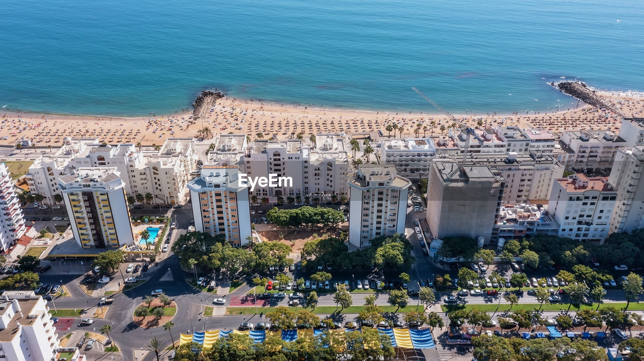 HIGH ANGLE VIEW OF BUILDINGS AGAINST SEA