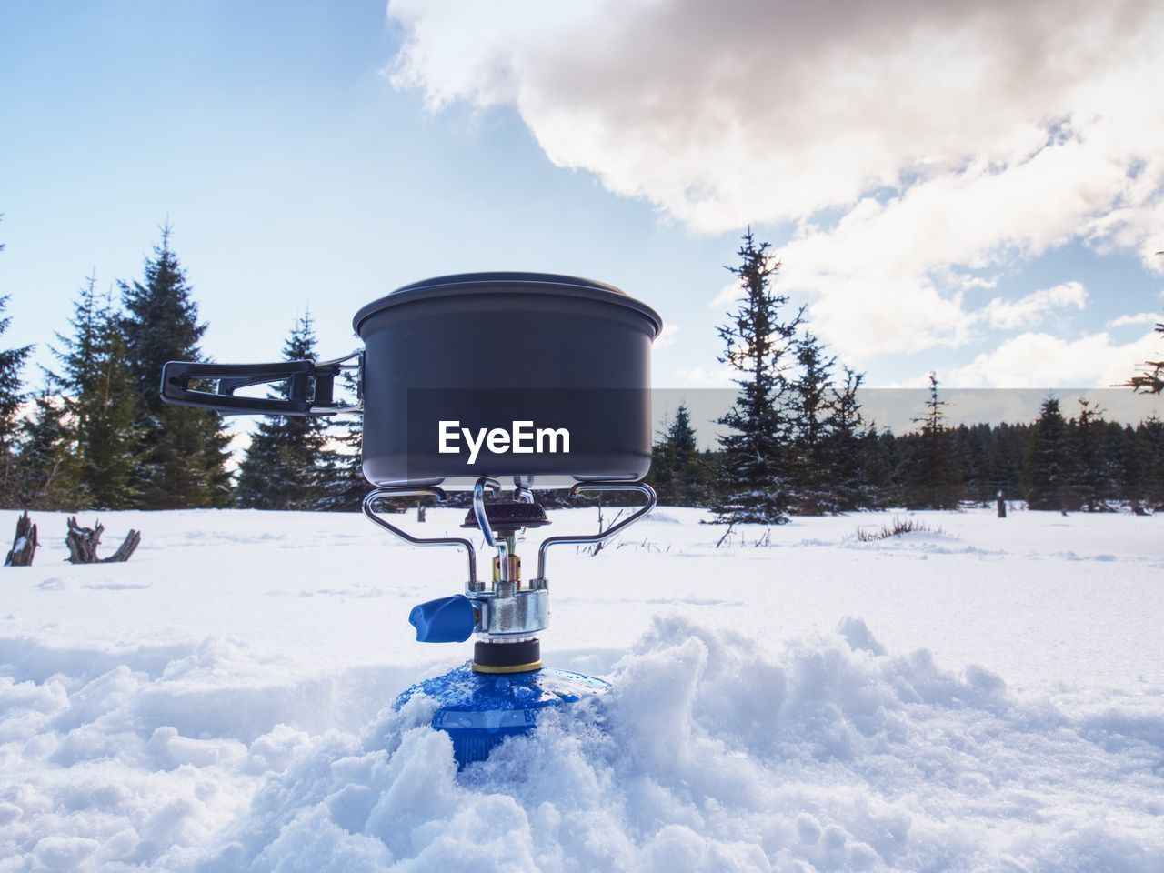 Cook at an winter outdoor campsite. cooking in winter with  black couldron above burning gas cooker