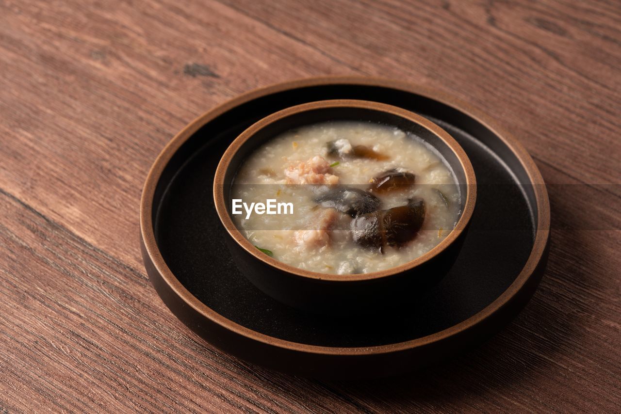 HIGH ANGLE VIEW OF SOUP IN GLASS ON TABLE