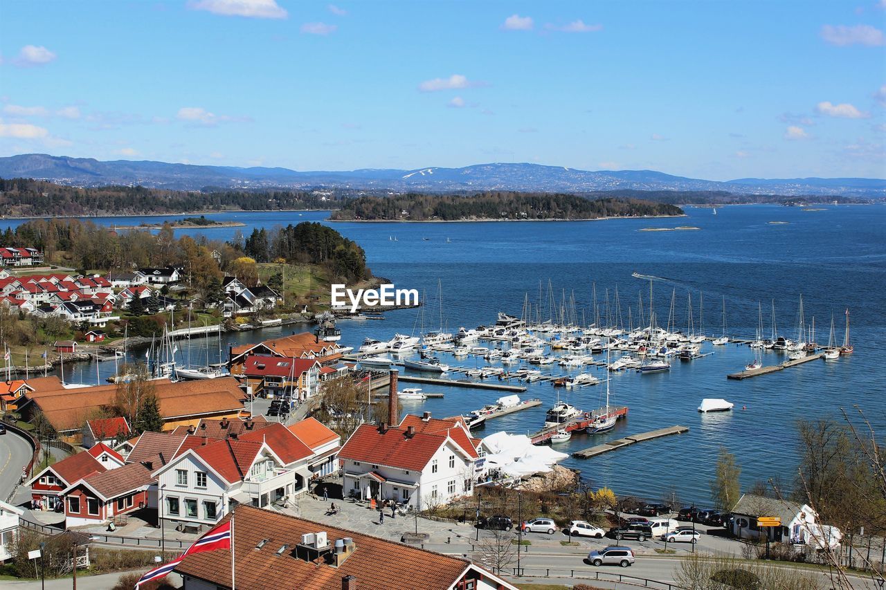 High angle view of town by sea against sky