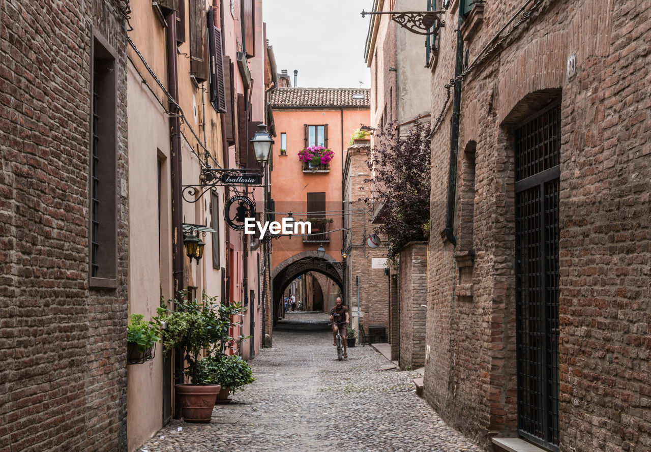 ALLEY AMIDST BUILDINGS IN CITY