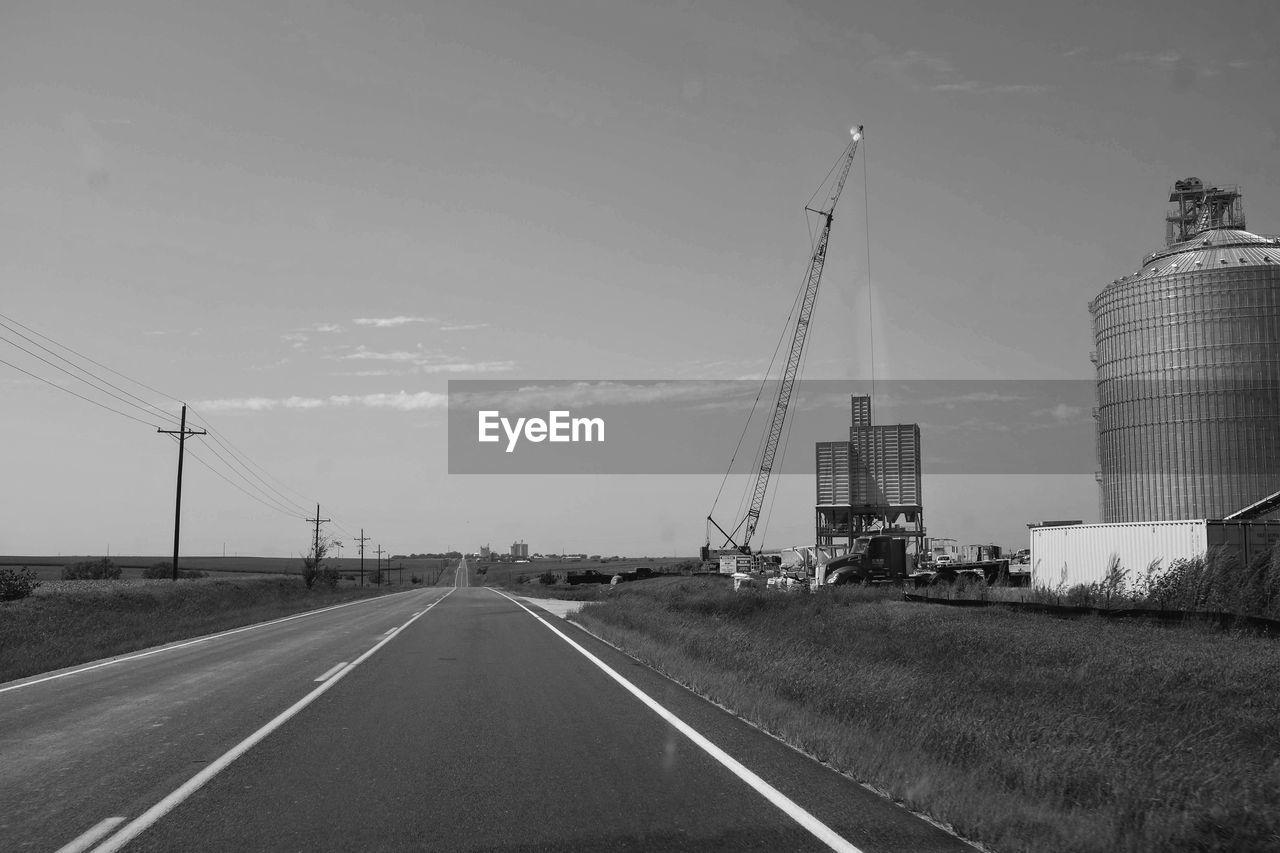 VEHICLES ON ROAD AGAINST SKY